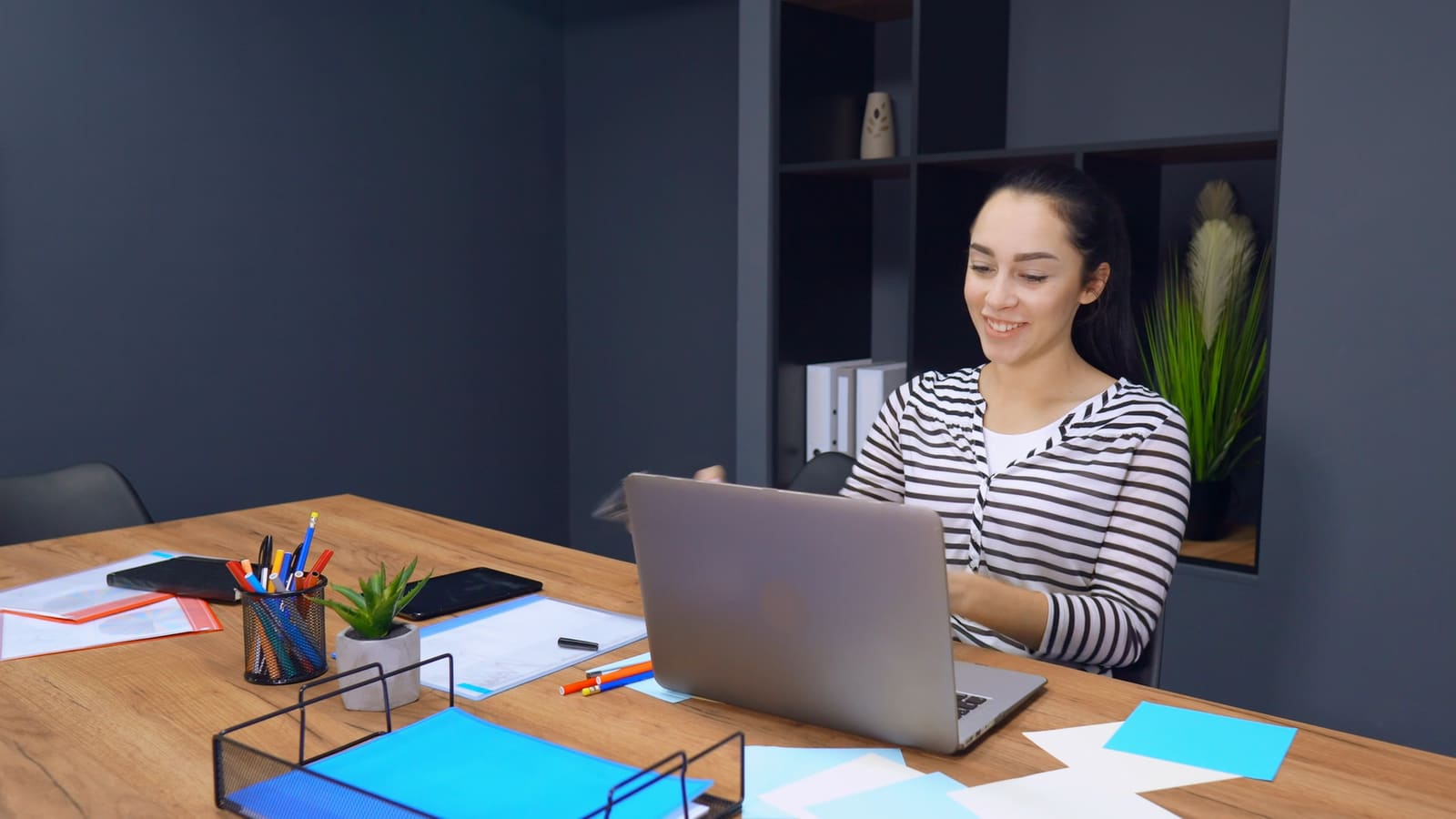Una persona sonriente del equipo de soporte en una videollamada con su portátil